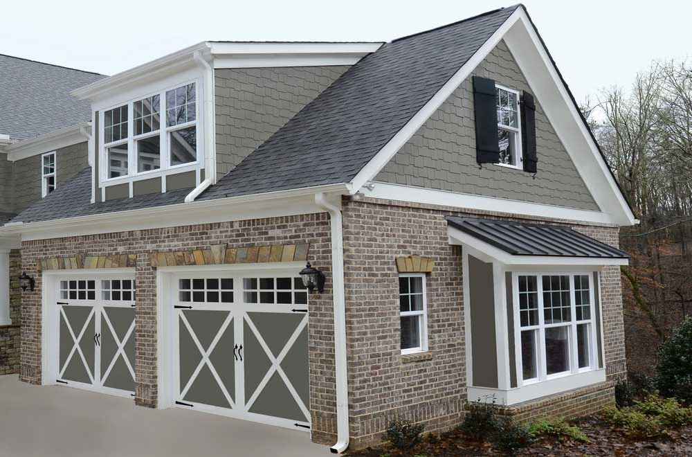 Elegant brick home with gray accents and carriage-style garage doors.