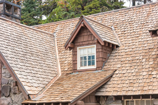 Close-up of a house with brown wooden shingle roofing and a small dormer window.